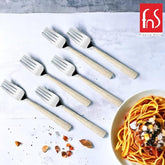 Six decorative forks with textured gold handles arranged with pasta dish